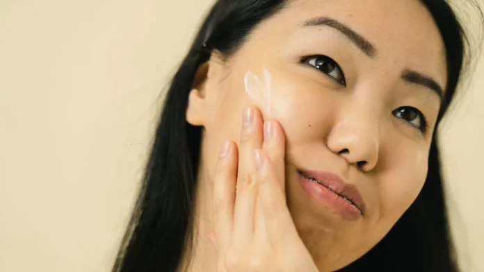 Woman applying anti-aging skincare cream to her face