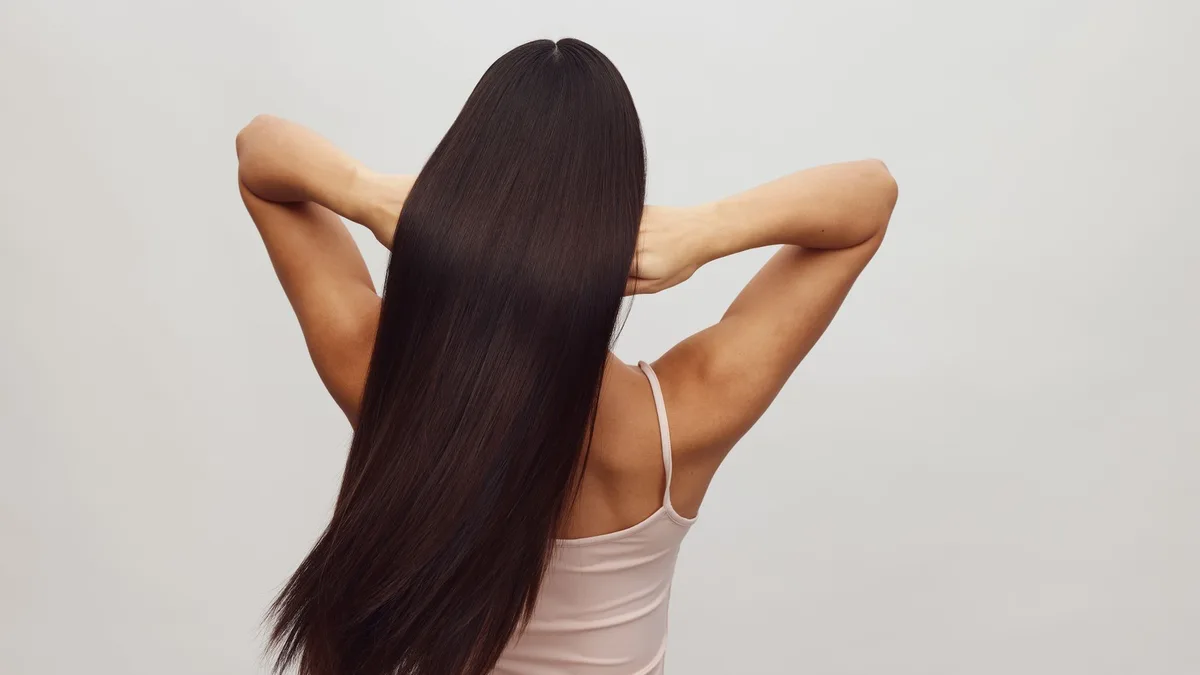 Woman with long smooth shiny hair seen from behind