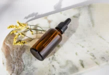 Anti-Frizz Serum: How It Works and How Much to Actually Use Anti-frizz hair serum dropper bottle on a marble surface