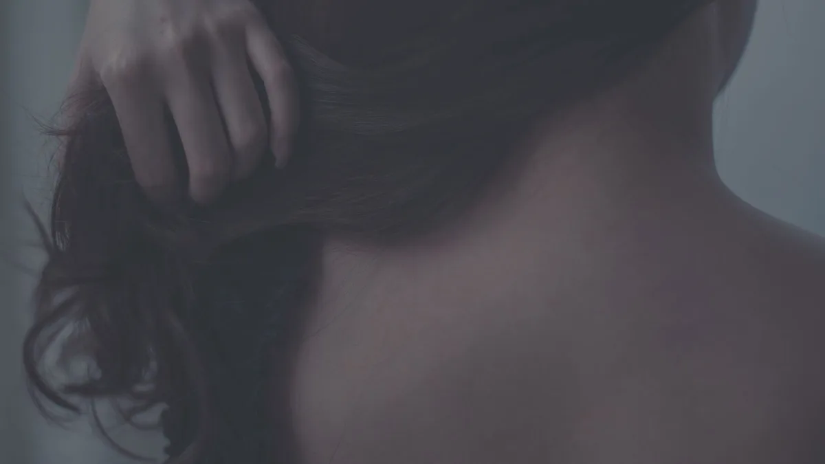 Close-up of a woman smoothing the lengths of her hair