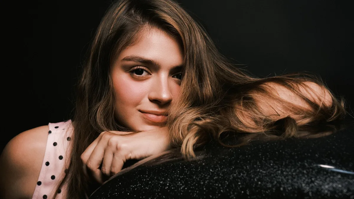 Close-up portrait of a young woman with sleek shiny hair