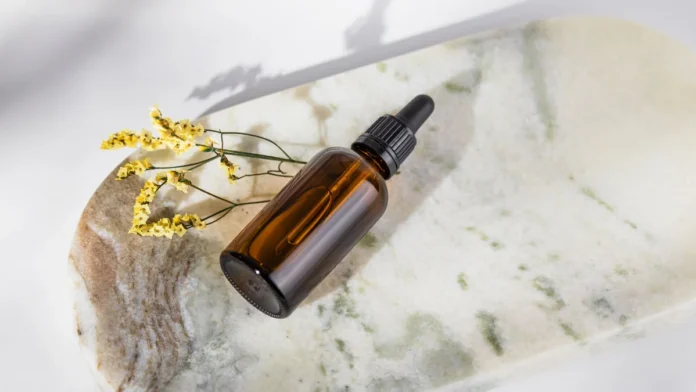 Anti-frizz hair serum dropper bottle on a marble surface