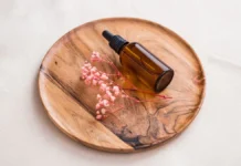 Bakuchiol: The Gentler Retinol Alternative, Examined Botanical bakuchiol skincare serum dropper bottle with flowers
