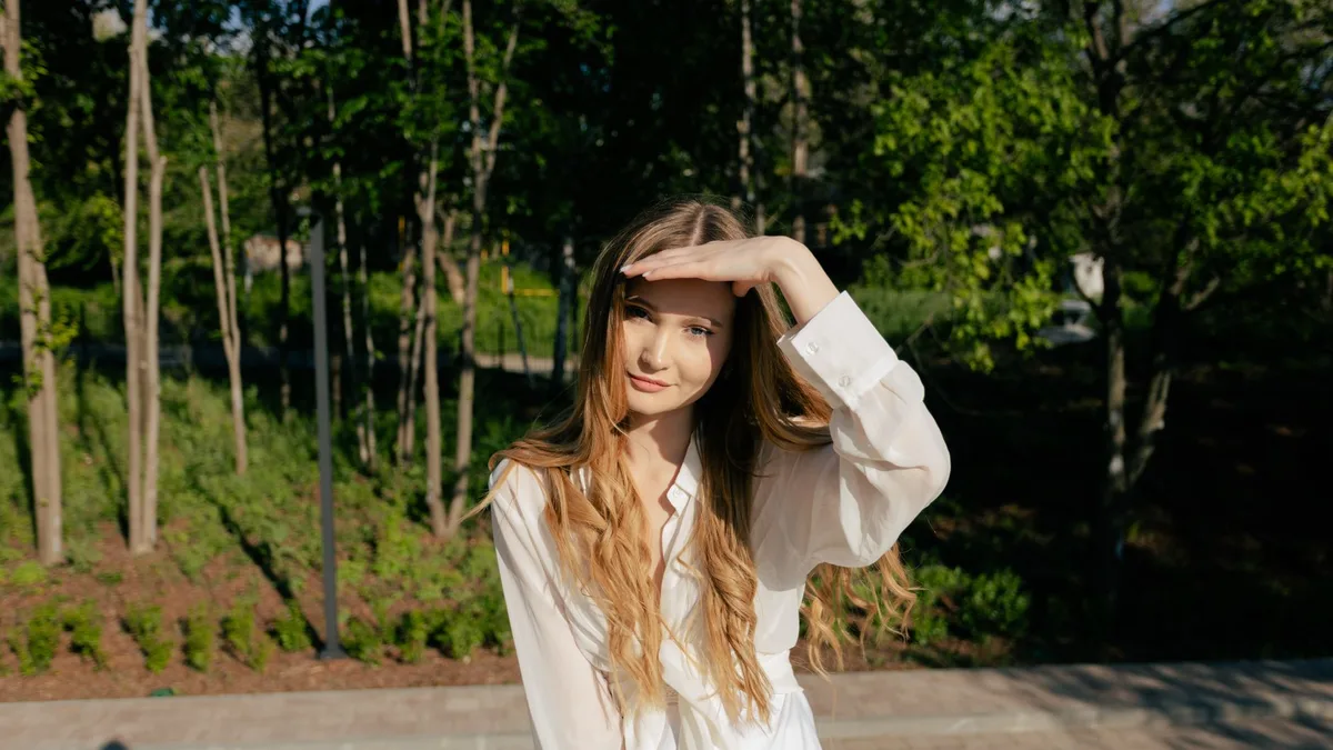Woman shielding her eyes from bright sunshine outdoors