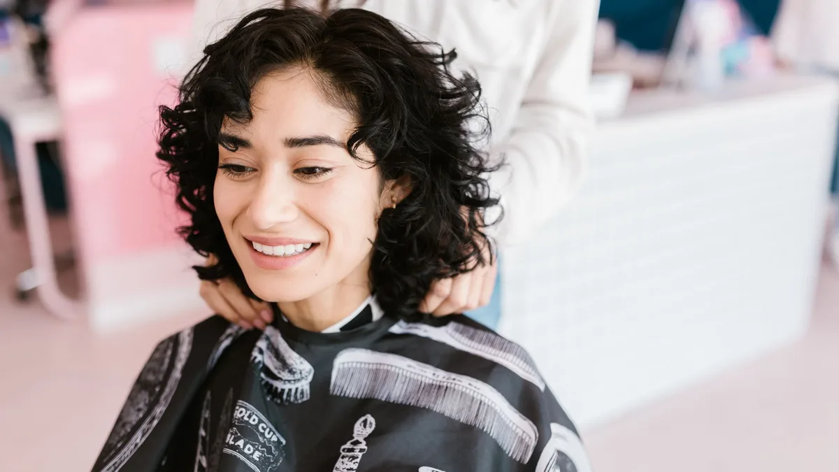 Smiling woman having her hair done in a salon