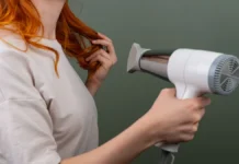 Best Blow Dryers: Ionic, Ceramic and Tourmaline Explained Woman blow drying her hair with a modern blow dryer