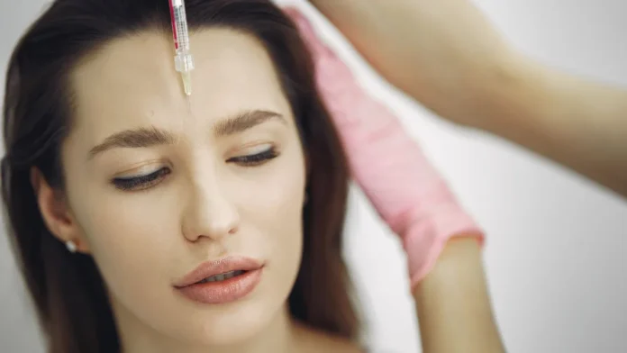 Botox Woman receiving a cosmetic forehead injection in a clinic