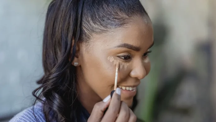 Woman applying concealer under her eye