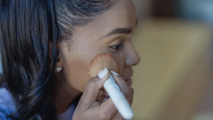 Contouring vs Bronzer Applying bronzer and contour powder to the cheek