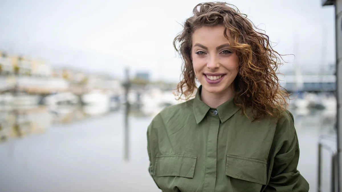 Woman with loose wavy hair smiling outdoors
