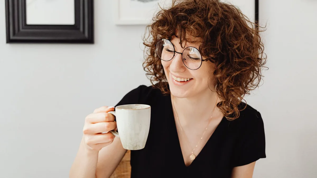 Woman with curly hair relaxing at home with a cup of coffee