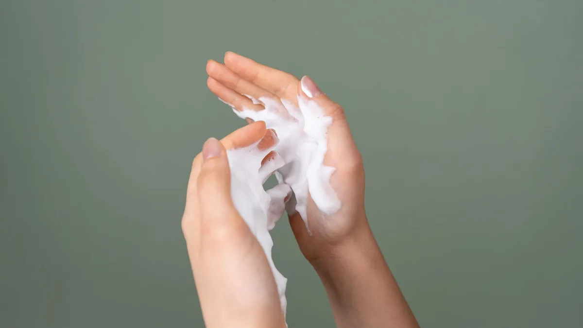 Close-up of hands with a palmful of styling foam