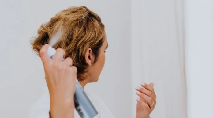 Curl Refreshing Spray: How to Revive Day-2 and Day-3 Curls Without Washing Woman spraying her hair with a curl refreshing spray