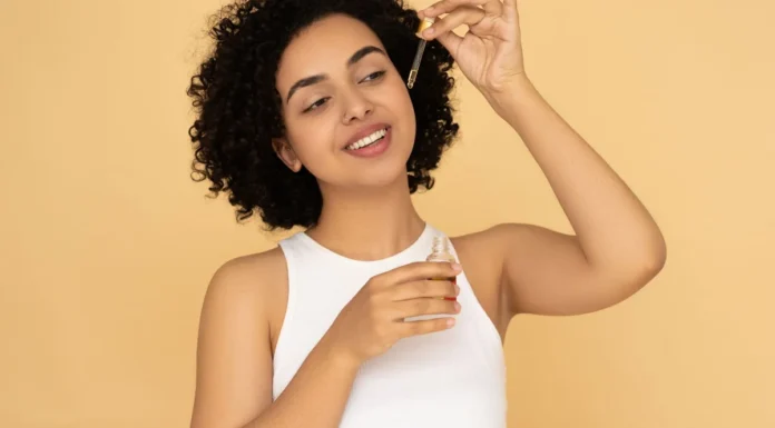 Curl Revival Products: How to Repair Damaged Curls (and What Cannot Be Fixed) Woman with curly hair applying a revival hair serum