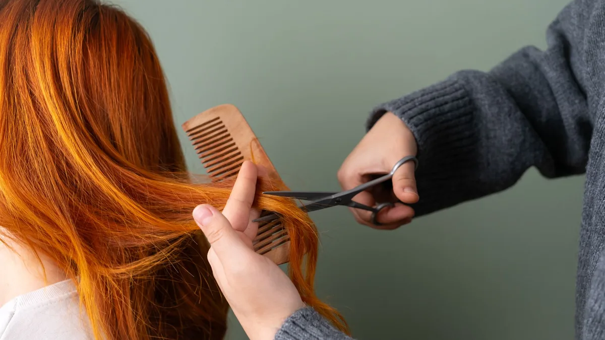 Close-up of hair ends being trimmed with scissors and comb
