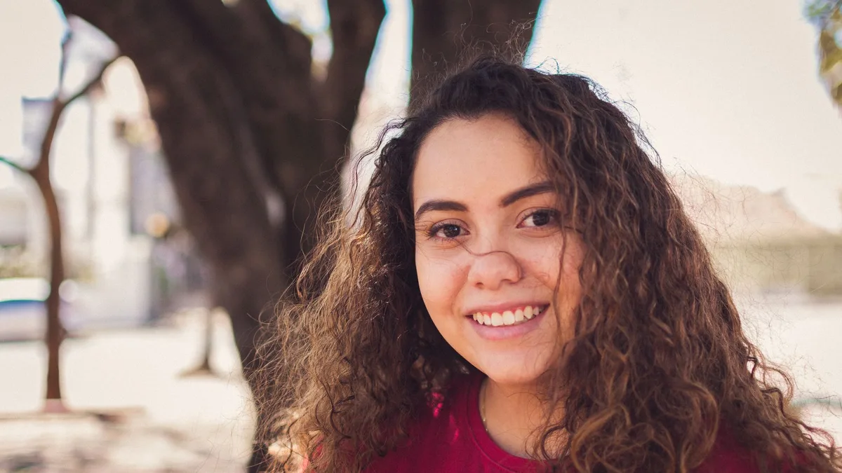 Smiling woman with defined natural curly hair outdoors