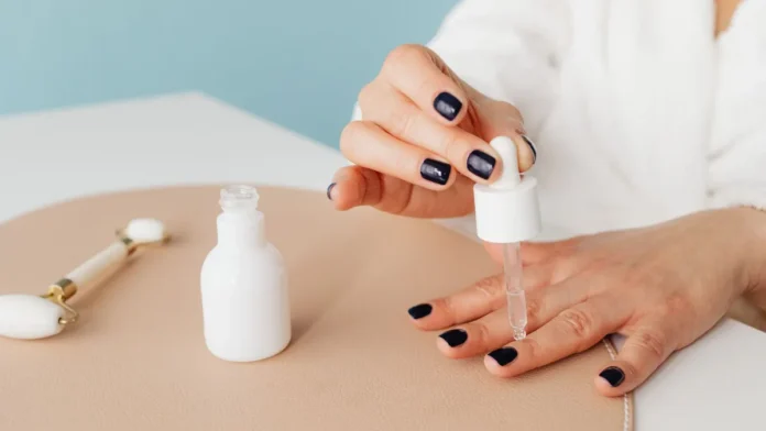 Cuticle Care Applying cuticle oil with a dropper to the nails