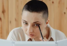 Eyeliner Types: Pencil, Gel, Liquid and Which Suits Your Eye Shape Woman applying eyeliner while looking in a mirror