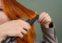 Flat Iron vs Curling Iron: Which One Does Your Hair Actually Need? Woman styling her hair with a flat iron straightener