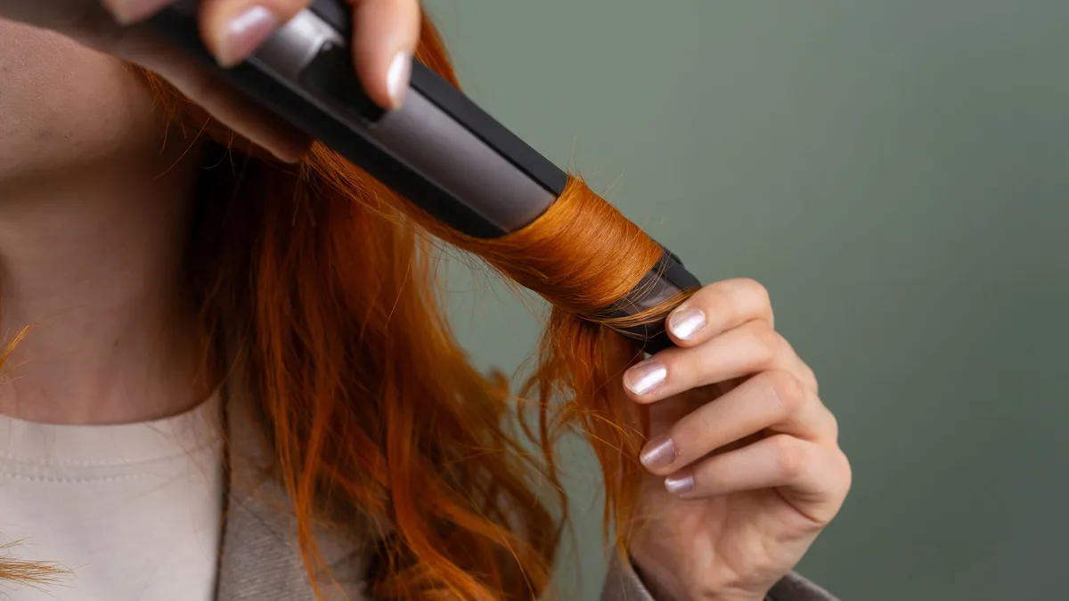Woman curling her hair with a curling iron