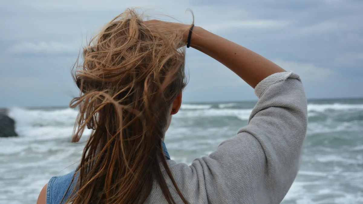 Back view of a woman with tousled beachy waves by the sea