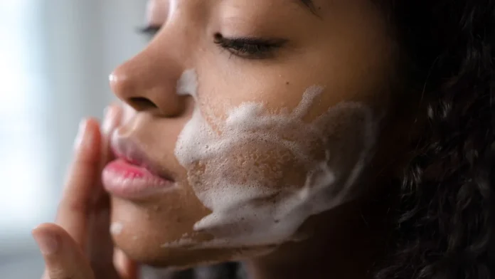 Foaming Cleansers Woman applying foaming cleanser to her face