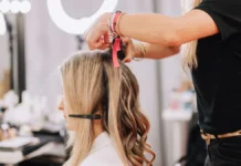 Hair Extensions and Wigs: A Complete Guide to Adding Length Stylist adding hair extensions to a woman's long hair