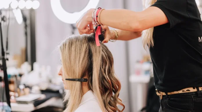 Hair Extensions and Wigs: A Complete Guide to Adding Length Stylist adding hair extensions to a woman's long hair