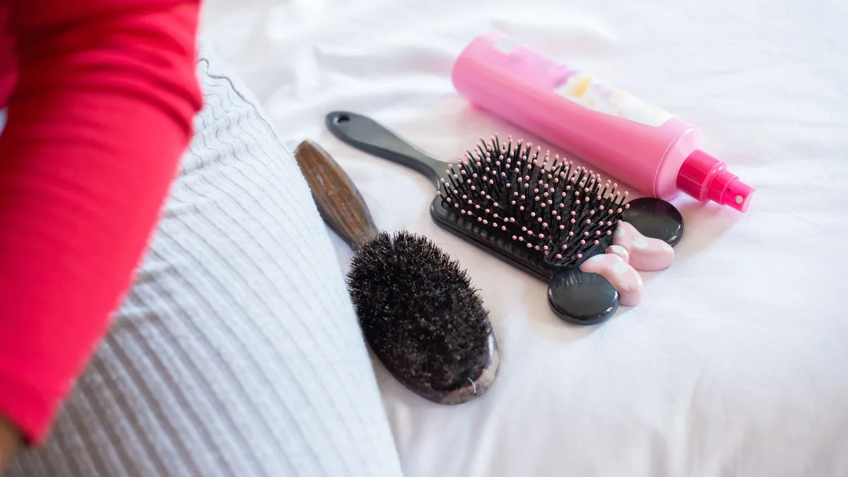 Hair styling tools and products laid out on a surface