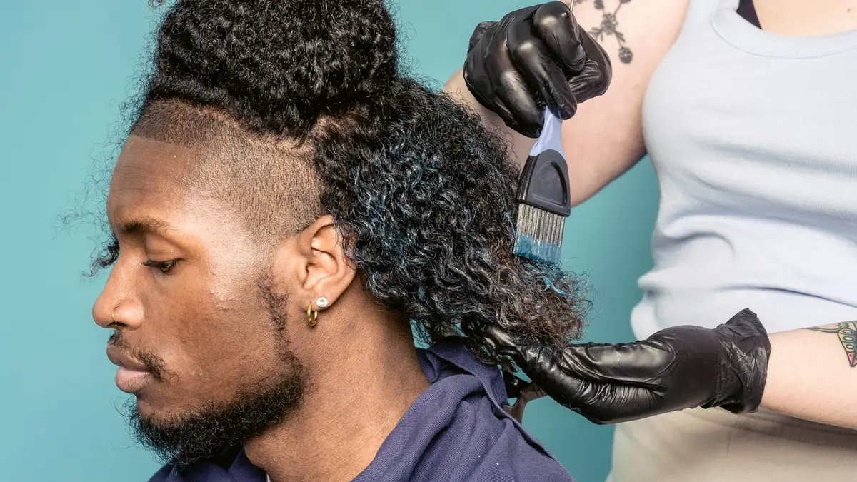 Hairdresser in gloves applying a treatment through sectioned hair