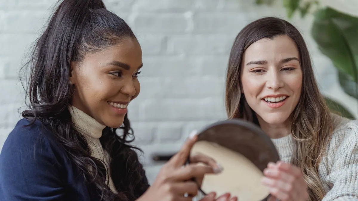 Smiling woman checking her styled hair in a mirror