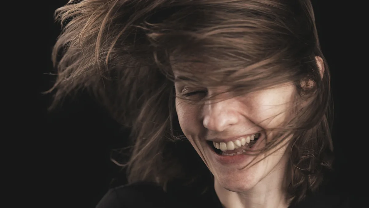 Smiling woman with hair in motion in a studio