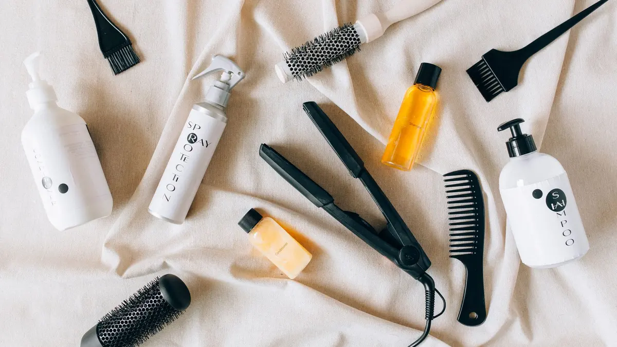 Hair care products and styling tools arranged on a surface