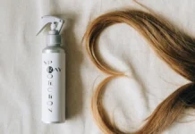 Heat Protectant Spray: Why Skipping It Costs You Length Heat protectant hair spray bottle beside styled hair