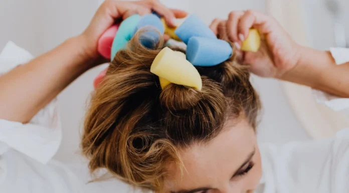 Heatless Curls: The Methods That Actually Work (and How Damp Your Hair Should Be) Woman using colourful foam rollers for heatless curls