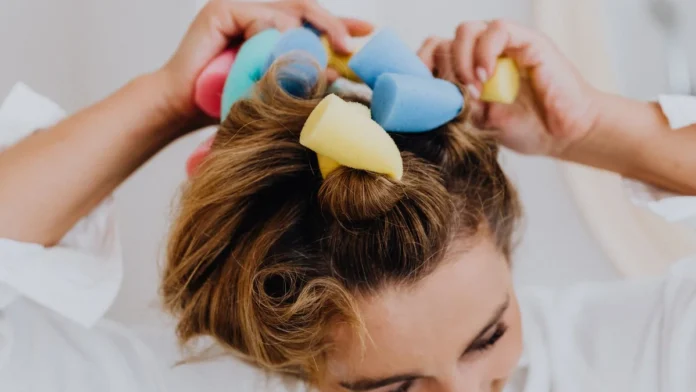 Woman using colourful foam rollers for heatless curls