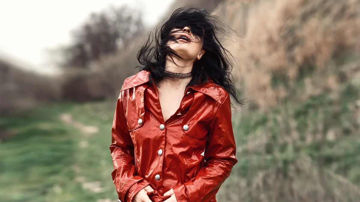 Woman in a red coat outdoors on a windy day