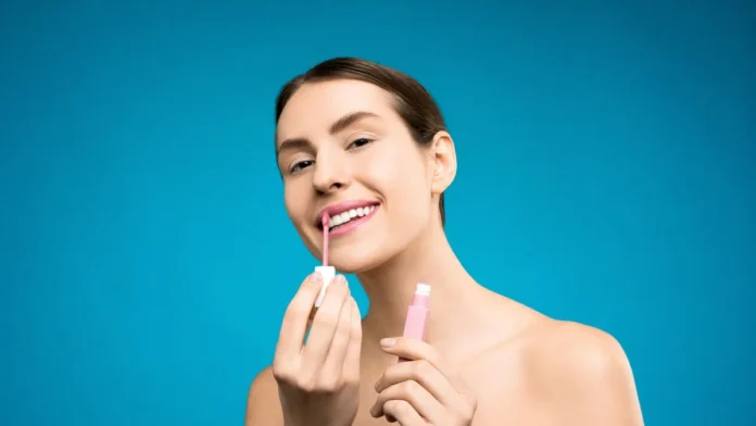 Lip Oils vs Lip Balms Woman applying glossy lip oil