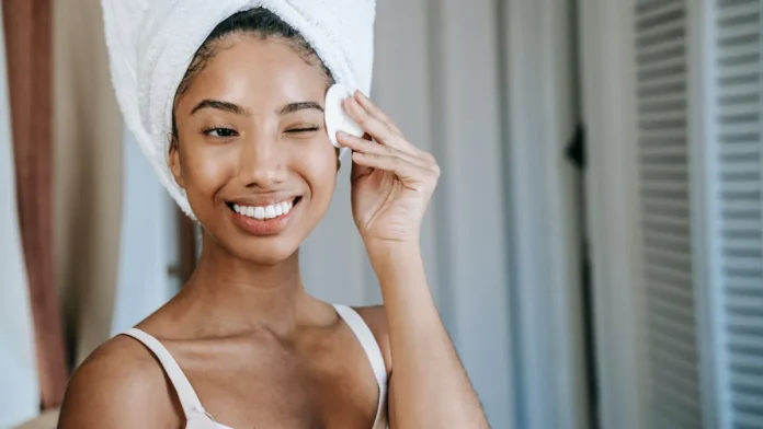 Makeup Removers and Wipes Woman removing makeup with a cotton pad
