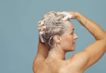 Purple Shampoo: How Long to Leave It On Without Going Ashy Blonde woman shampooing her hair to tone brassiness