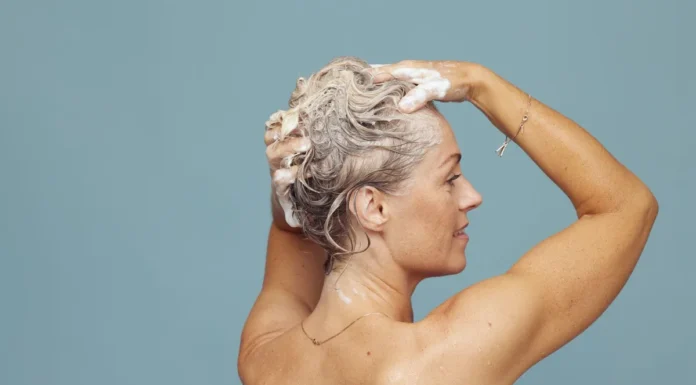 Purple Shampoo: How Long to Leave It On Without Going Ashy Blonde woman shampooing her hair to tone brassiness