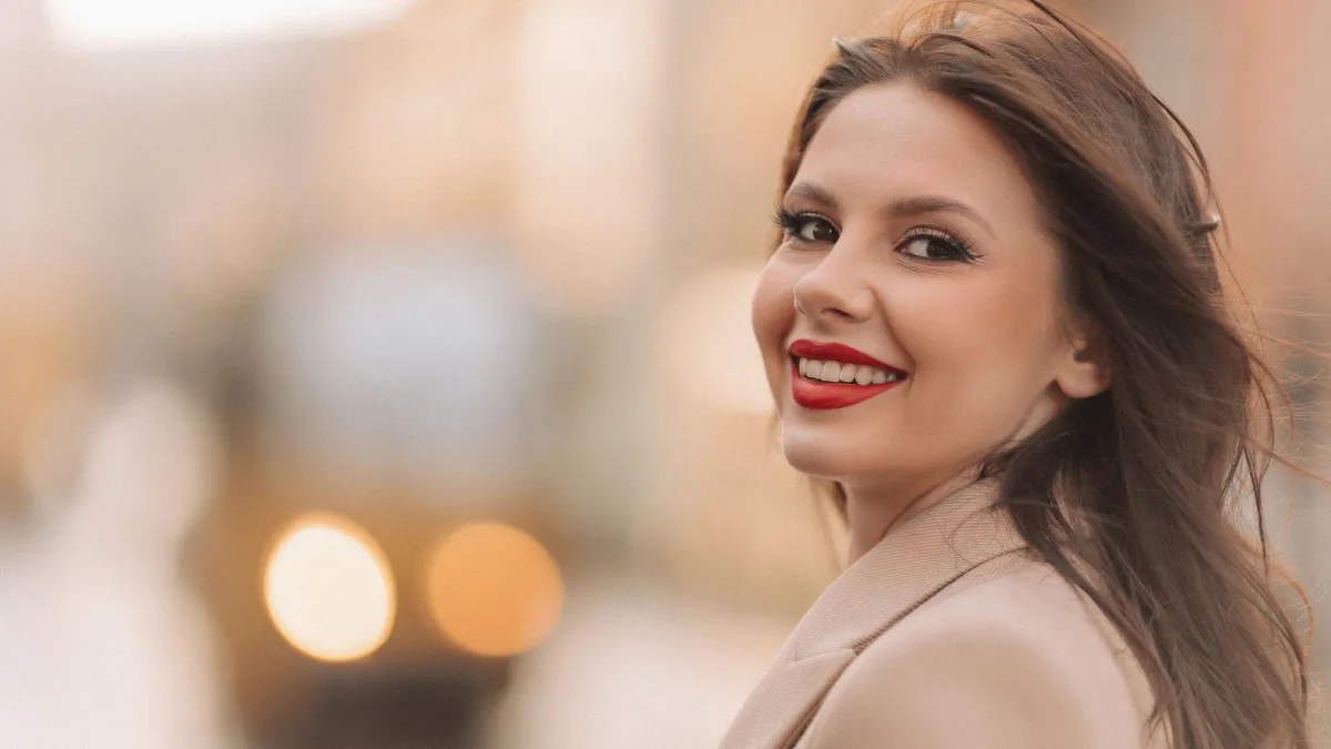 Smiling woman with glossy brown hair outdoors