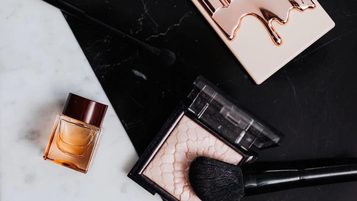 Flat lay of beauty products including compacts and brushes