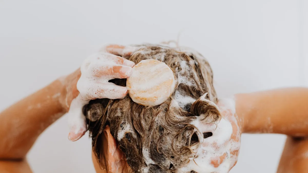 Close-up of hair being washed with lather at the roots