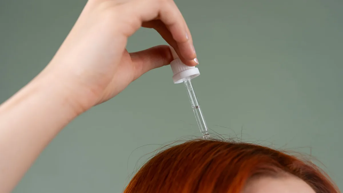 Scalp serum being applied with a dropper