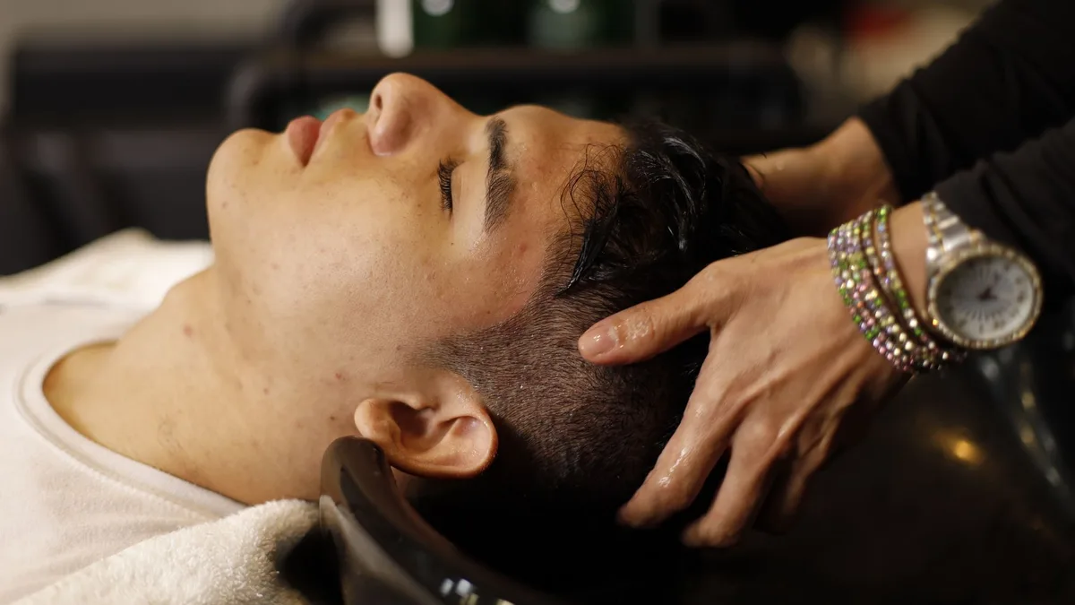 Person relaxing during a scalp wash at a salon basin