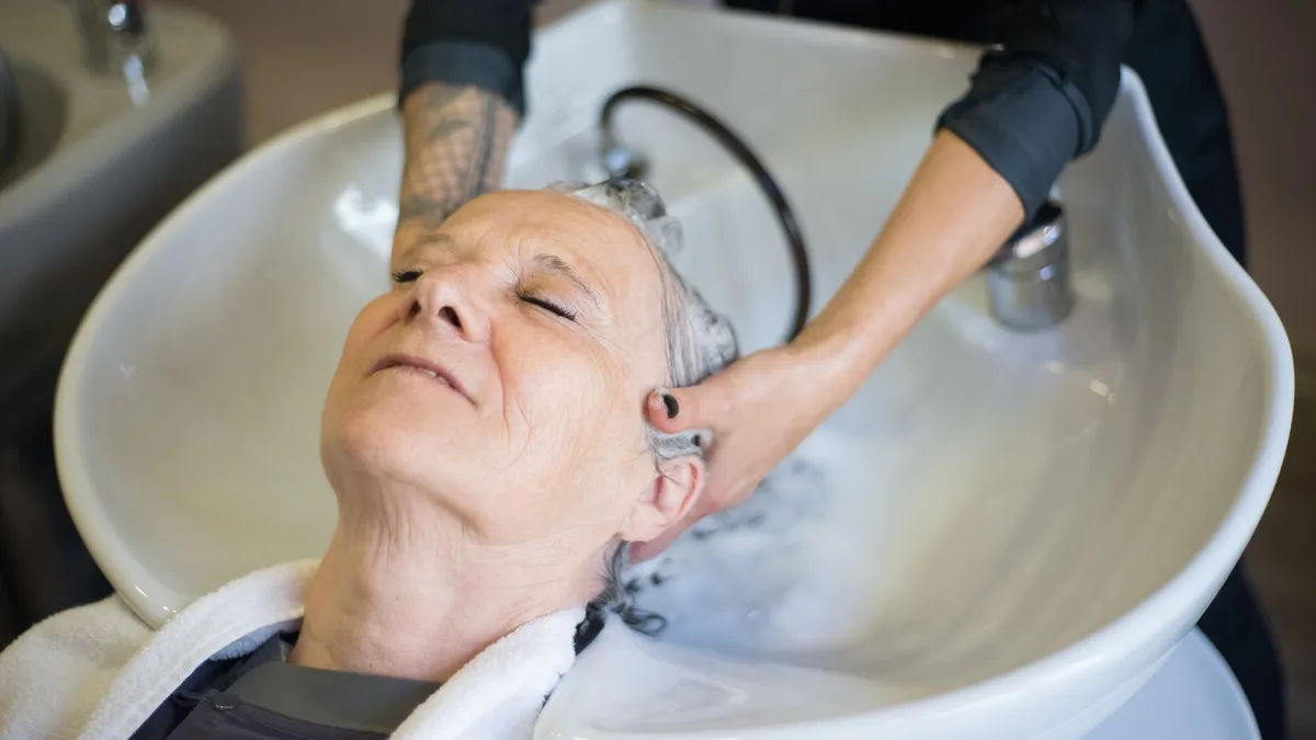 Woman relaxing during a scalp massage at a salon