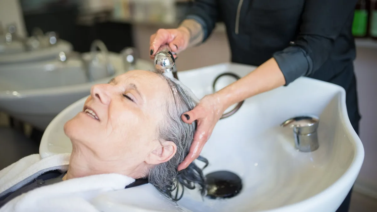 Woman enjoying a soothing hair wash at a salon