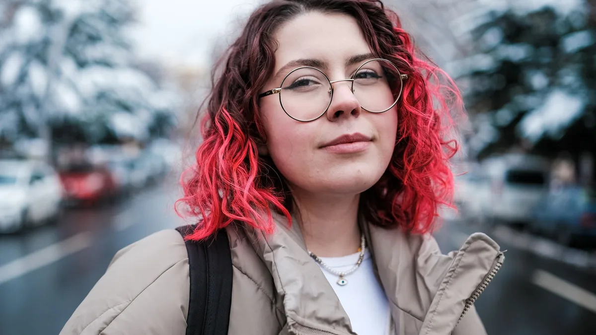 Smiling woman with bright pink dyed hair outdoors