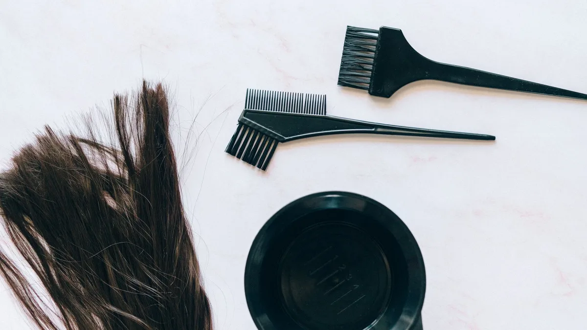 Overhead view of hair colouring tools and dyed hair strands